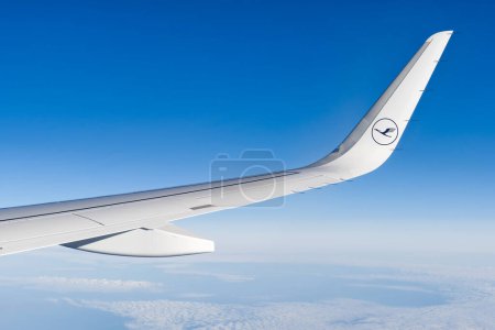 Téléchargez les photos : 20.05.2022 - Tallinn, Estonie. . Vue de l'aile et du logo de l'avion Lufthansa à travers la fenêtre dans le ciel et les nuages du ciel à travers le hublot d'un avion à aile d'avion - en image libre de droit