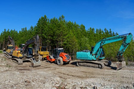 Foto de Equipo pesado de construcción, tractores, excavadoras y excavadoras estacionadas en un estacionamiento forestal. Nueva instalación de línea de comunicación - Imagen libre de derechos