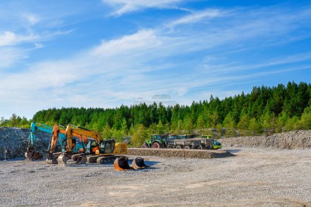 Photo for Heavy Construction Equipment, Tractors, Excavators, and Bulldozers Parked in a Forest Parking Lot. New Communication Line Installation - Royalty Free Image