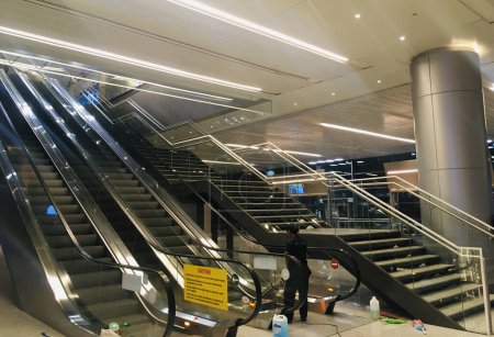 Foto de Escalera y escaleras mecánicas en la Sala de Salida de la Nueva Extensión Terminal en el Aeropuerto Internacional Rajiv Gandhi - Hyderabad, India el 14 de abril de 2024 - Stock Image as JPG File - Imagen libre de derechos