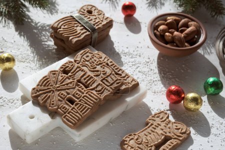 Speculoos or Spekulatius, Christmas biscuits, chocolate balls and almonds on a table with fir twigs. Traditional German sweets, cookies for Christmas or Advent, wintertime snacks.
