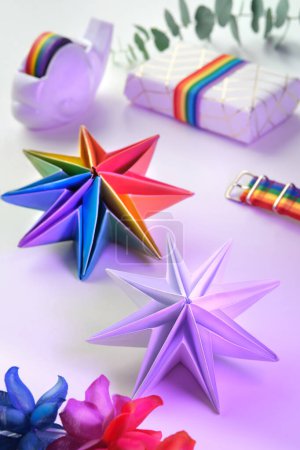 Photo for Vibrant neon rainbow origami paper stars. LGBTQ community rainbow flag colors. handmade DIY Christmas decor, copy-space. Origami Xmas stars and gifts in boxes. Handmade decor for LGBT. - Royalty Free Image
