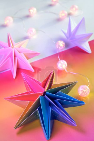Photo for Vibrant neon rainbow origami paper stars. LGBTQ community rainbow flag colors. handmade DIY Christmas decor. Self made Xmas stars made from vibrant colored paper. Handmade LGBT pride decor. - Royalty Free Image
