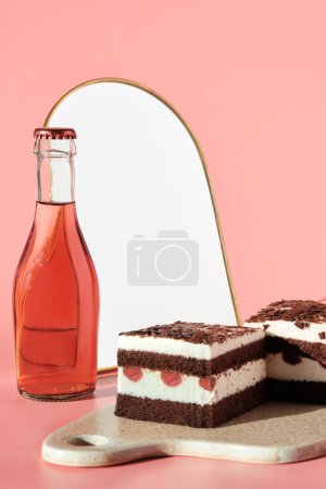 Photo for Chocolate cake with sour cherries. Two pieces of cake on cutting board. Sweet dessert and rosa, pink vine on pink background. Copy-space, place for text on white in arch mirror. - Royalty Free Image