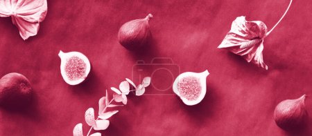 Foto de Banner panorámico Fondo otoñal con frutas frescas de higo cortadas a la mitad. Flores secas de eucalipto y lirio de cala pintadas de rosa metalizado sobre fondo marrón oscuro. - Imagen libre de derechos