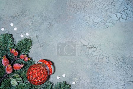 Foto de Fondo de Navidad. Puesta plana con ramas de abeto decoradas con bayas de rowan rojo y baratijas de vidrio sobre fondo texturizado verde gris. - Imagen libre de derechos
