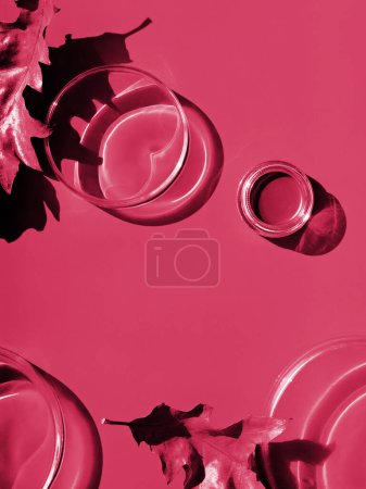 Photo for Toned monochrome cosmetics image in Viva Magenta color of the year 2023. Black cosmetic product in plastic jar on paper background. Glass petri dishes, Direct sunlight, long shadows. - Royalty Free Image