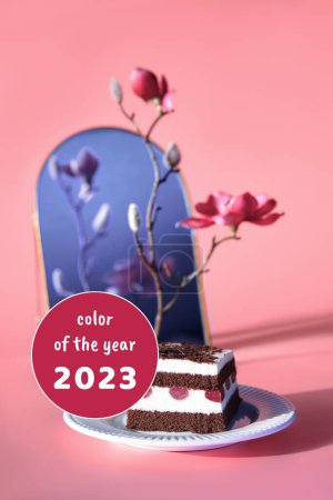 Photo for Viva Magenta color of the year 2023. Chocolate cake with cherries. Piece of cake on a plate reflected in arch mirror. Sweet dessert on pink background with magnolia blossoms. - Royalty Free Image