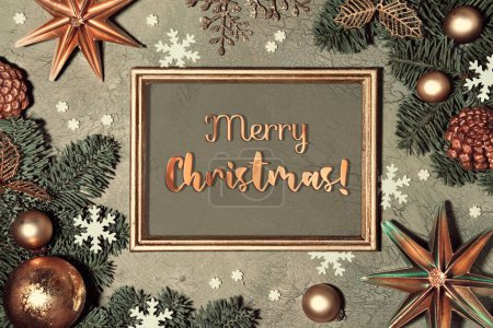 Photo for Christmas background. Flat lay with fir twigs decorated with red rowan berry, paper stars and snowflakes on grey green textured background. Greeting text Merry Christmas in frame. - Royalty Free Image