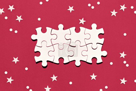 Photo for Puzzle pieces in the middle of red background toned in Viva Magenta color of the year 2023. Christmas background with snowflakes and stars. Christmas winter abstract festive background, copy-space. - Royalty Free Image