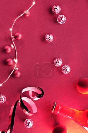 Téléchargez les photos : Viva Magenta couleur de l'année 2023. Fond rouge foncé de Noël. Pose plate monochromatique avec boules disco, boules et guirlande de lumières électriques festives sur fond textile en soie rouge. - en image libre de droit