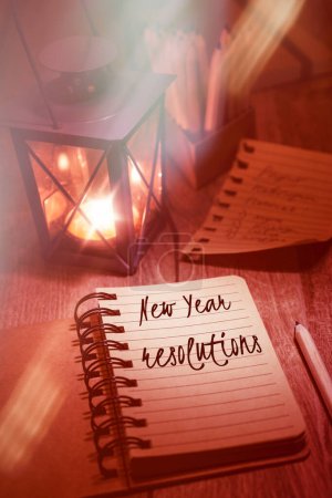 Téléchargez les photos : Résolutions du Nouvel An handwring dans le carnet. Lampe à thé en n métal vintage lanterne, page arrachée et pensils sur table en bois. fond vintage tonique. - en image libre de droit