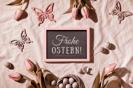 Photo for Sepia tinted Easter background. Decorated background with blackboard. Text Frohe Ostern means Happy Easter in German language. Fresh Spring tulips and quail eggs. Top view, flat lay, springtime decor. - Royalty Free Image