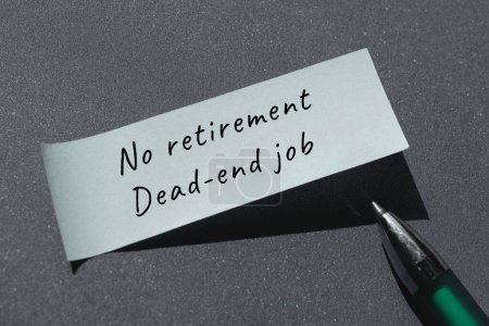 Photo for No retirement, dead-end job words written on paper note with pen. Handwritten note, caption, text. Top view, flat lay on dark grey paper background. - Royalty Free Image