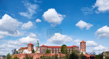 Téléchargez les photos : Côté rivière de Cracovie en Pologne avec vue sur le château de Wawel. Tourné de l'autre côté de la Vistule. Jour d'été, ciel bleu avec nuages. - en image libre de droit