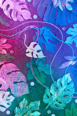 Téléchargez les photos : Fond lumineux au néon avec des fils lumineux et des feuilles tropicales exotiques en rose vif, violet et bleu. Cadre fabriqué à partir de feuilles de papier exotiques. Artisanat papier fond. - en image libre de droit