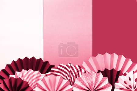 Foto de Círculo de fans y confeti sobre fondo rosa. Frontera creativa con espacio para saludo de texto. Modernas decoraciones vibrantes en rosa, blanco y negro - Imagen libre de derechos