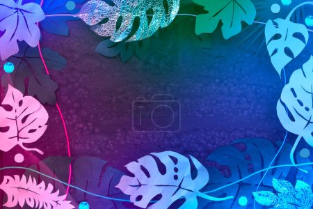 Foto de Fondo vibrante iluminado por neón con alambres ligeros y hojas tropicales exóticas en rosa brillante, púrpura y azul. Marco hecho de hojas de papel exóticas. Papel artesanal fondo. - Imagen libre de derechos