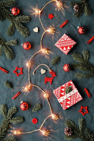 Foto de Beato Yule, Navidad, Festival de invierno de Letonia. Símbolos etnográficos, patrones de Letonia. Amuletos de madera, papel de regalo, cajas de regalo con ramas de abeto y bayas. Patrones bálticos, rojo sobre azul. - Imagen libre de derechos