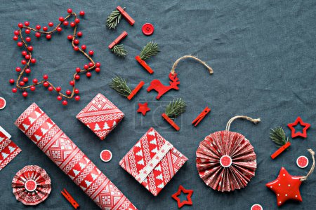 Photo for Blessed Yule, Christmas, Latvian winter festival. Ethnographic symbols, patterns from Latvia. Wood amulets, wrapping paper, gift boxes with fir twigs and berries. Baltic patterns, red on blue. - Royalty Free Image