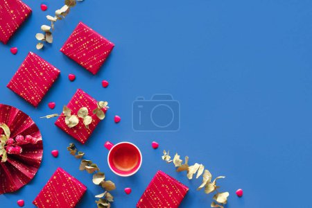 Photo for Wintertime magenta decor, gift boxes. Flat lay on dark blue linen textile, copy-space, place for text. Wrapped presents, paper fan, eucalyptus. Red blue corner arrangement, geometric composition. - Royalty Free Image