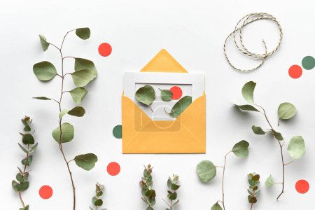 Photo for Eucalyptus Twigs in a Flat Lay on White Paper with an Envelope, Orange Circles and Cord - Royalty Free Image