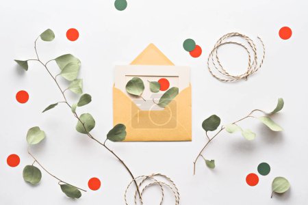 Téléchargez les photos : Brindilles d'eucalyptus posées sur un papier blanc avec une enveloppe, des cercles orange et un cordon - en image libre de droit