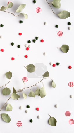 Foto de Las ramitas de eucalipto en un plano Encienda el papel blanco con un sobre, caramelo y dulces - Imagen libre de derechos