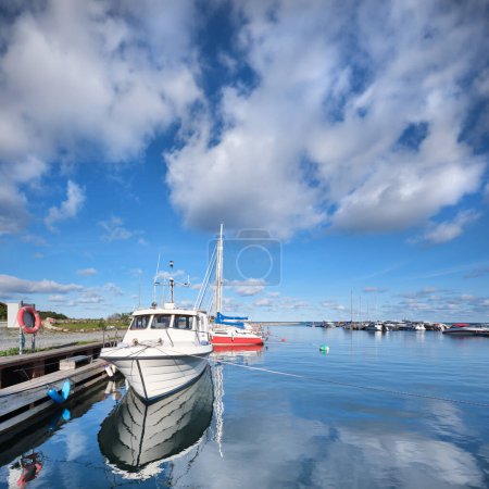 Téléchargez les photos : Un bateau est amarré à un quai avec d'autres bateaux dans l'eau. Port de Neeme dans le nord de l'Estonie. - en image libre de droit