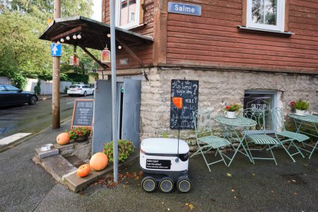 Téléchargez les photos : TALLINN, ESTONIE - 4 OCTOBRE 2023 : Un petit robot post-livraison assis devant un restaurant. - en image libre de droit