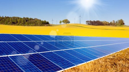 Foto de Un panel solar en un campo con turbinas eólicas en el fondo. Fuentes de energía alternativas. - Imagen libre de derechos