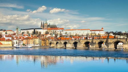 Foto de Puente de Carlos, Catedral de San Vito y otros edificios históricos de Praga, panorama desde la orilla opuesta del río - Imagen libre de derechos