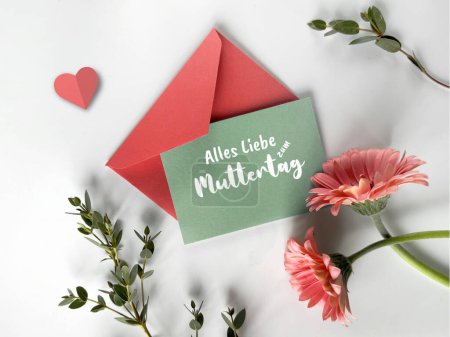 Photo for A photo featuring a green envelope placed next to a red envelope amidst vibrant pink flowers. - Royalty Free Image