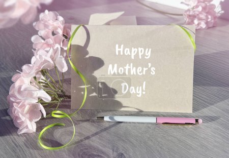 Une photographie avec une carte de la fête des mères placée à côté d'un bouquet de fleurs, symbolisant la célébration des mères.