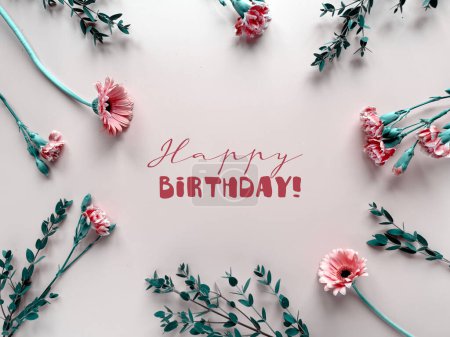 Foto de Una tarjeta de cumpleaños con elegantes flores de color rosa, que se cree que son claveles crema, rodeado de hojas verdes exuberantes. El diseño es delicado y vibrante, perfecto para celebrar una ocasión especial. - Imagen libre de derechos