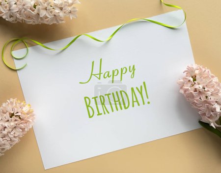 Téléchargez les photos : Une carte d'anniversaire vibrante et joyeuse ornée de fleurs colorées placées sur une table en bois, apportant une touche de joie à la célébration. - en image libre de droit