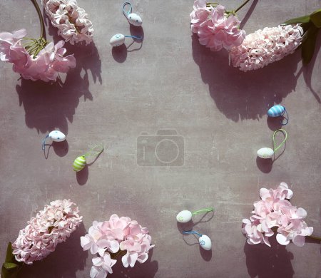 Photo for A group of pink spring flowers hyacinth and hydrangea sitting neatly arranged on top of a table with Easter eggs, copy-space. - Royalty Free Image