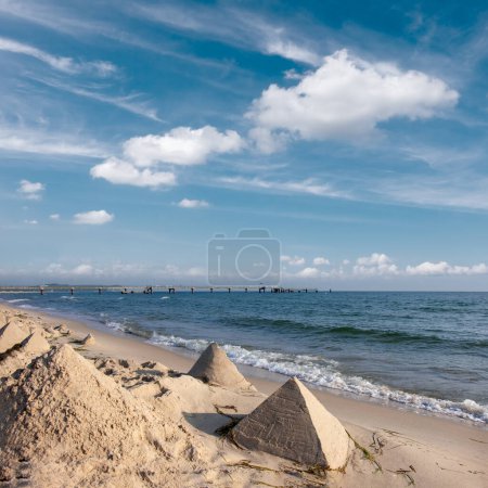 Téléchargez les photos : Une plage de sable avec plusieurs pyramides de sable créées sur le rivage. Rivages romantiques de la mer Baltique. - en image libre de droit