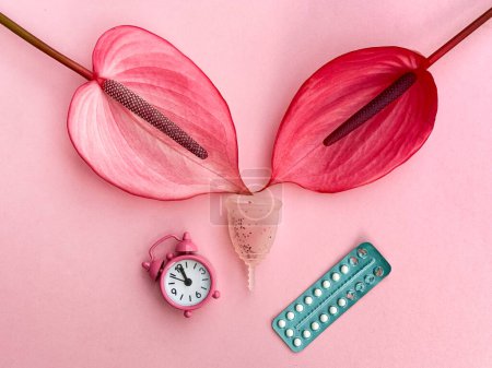 Photo for Feminine Health Concept with Menstrual Cup, Birth Control Pills, and Anthurium Flowers on Pink Background. - Royalty Free Image