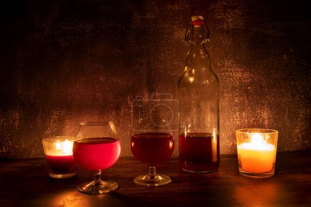 Foto de A bottle of wine with glasses by candlelight - Imagen libre de derechos