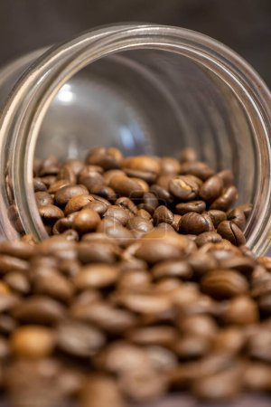 Téléchargez les photos : Spilled coffee beans from a glass jar. - en image libre de droit