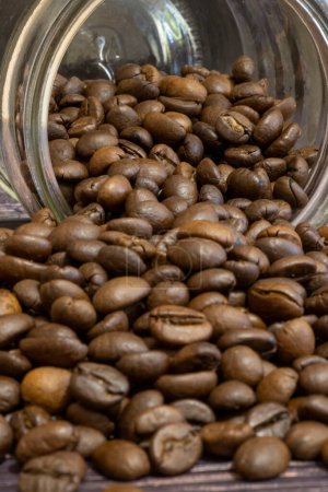 Téléchargez les photos : Spilled coffee beans from a glass jar. - en image libre de droit