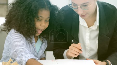 Photo for Creative class in diversity school Caucasian teacher with African kid having fun learning critical thinking global citizen education conceptual - Royalty Free Image