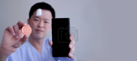 Téléchargez les photos : Asiatique homme montrant crypto et téléphone intelligent accident blesser saine gestion des risques d'investissement - en image libre de droit