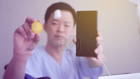 Photo for Asian man showing crypto and smart phone accident injure healthy investment risk managment - Royalty Free Image