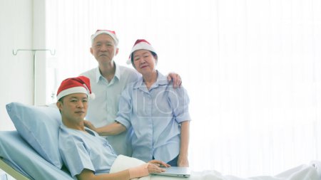 Téléchargez les photos : Famille asiatique célébrant Noël et le Nouvel An à l'hôpital enfant admettre récupération bonne relation familiale éther - en image libre de droit