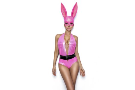 Photo for Sexy blonde woman is posing in latex Easter bunny costume and pink bunny mask on white background. Easter bunny concept. - Royalty Free Image