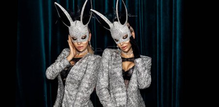 Sexy blonde woman dressed in Easter bunny mask and sexydress and is posing on dark velvet background. Easter bunny costume - Image.