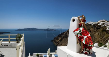 Téléchargez les photos : Belle femme élégante en robe longue à fleurs pose dans un complexe de luxe à Santorin. Modèle féminin en robe longue incroyable. - en image libre de droit
