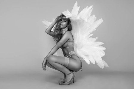 Foto de Hermosa mujer rubia sexy en lencería elegante y alas de ángel está posando sensualmente en el estudio. Angel en lencería, foto artística en blanco y negro - Imagen libre de derechos